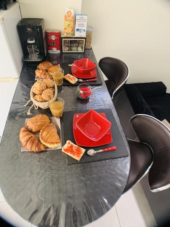 a black table with a bunch of food on it at Appartement cosy proche Roissy CDG Astérix DisneyLand Paris in Goussainville