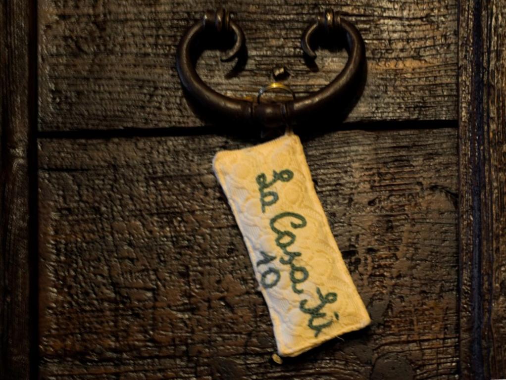 a tag on a wooden door with a handle at La Casa Sù Le Dimore Del Borgo in Santo Stefano di Sessanio