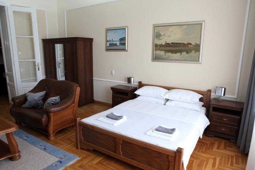 GoldStar Osijek في أوسييك: غرفة نوم فيها سرير وكرسي