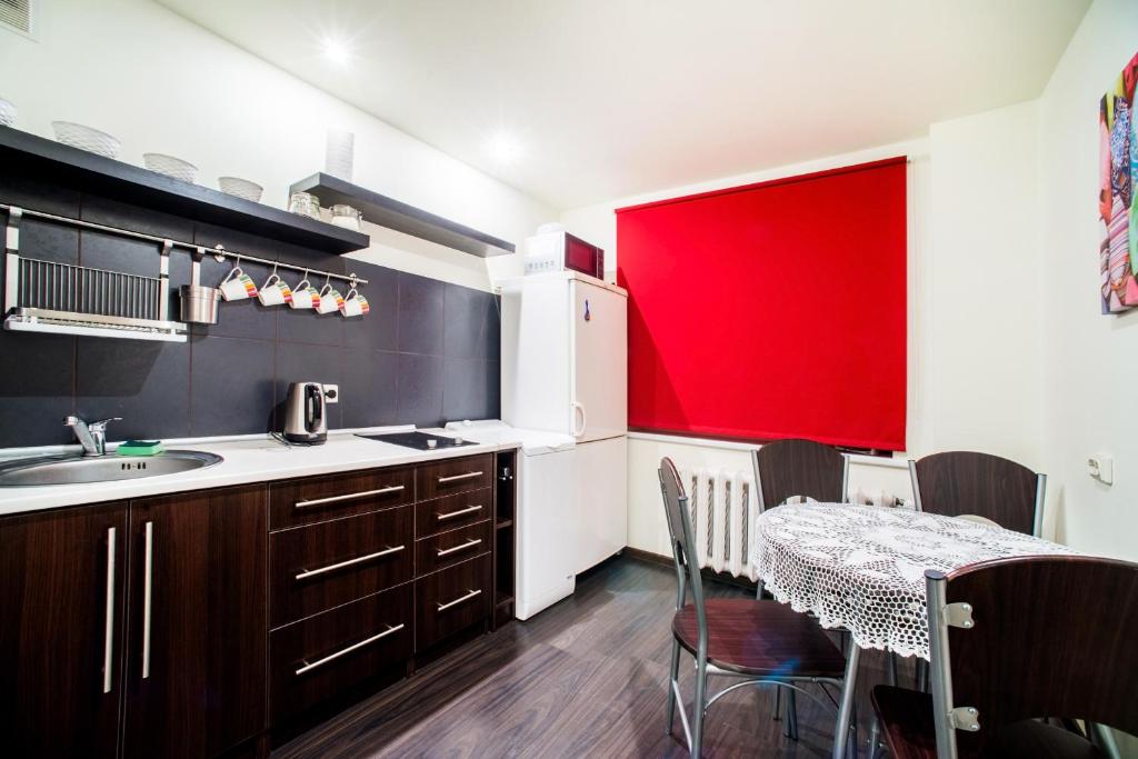 une cuisine avec une table et un mur rouge dans l'établissement Apartment Stay In, à Druskininkai