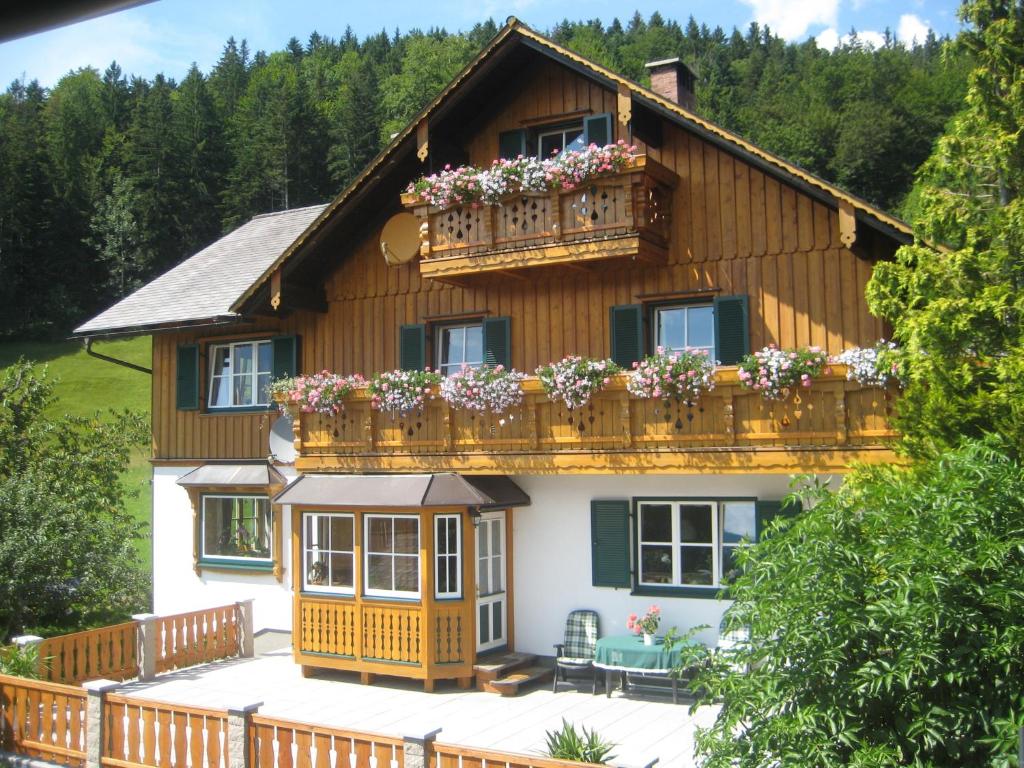 una casa con un balcón con flores. en Haus Schrei, en Grundlsee