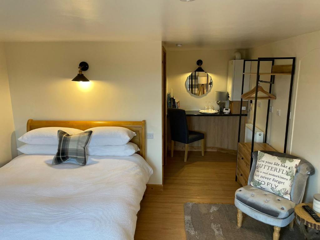 um quarto com uma cama, uma cadeira e uma mesa em Little Buttercup Cottage em Brackley