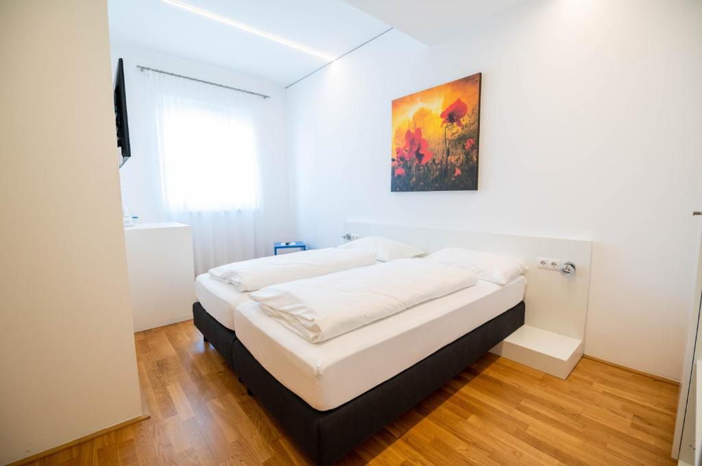 1 cama en un dormitorio con una pintura en la pared en sHome Hotel Graz - Self-Check-in & free parking, en Graz