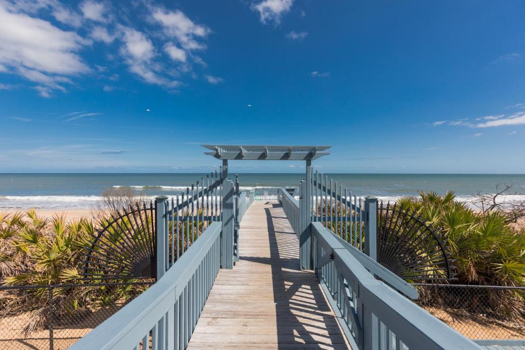 a wooden boardwalk to the beach with the ocean at SouthernVilla Ticket to Paradise in Palm Coast
