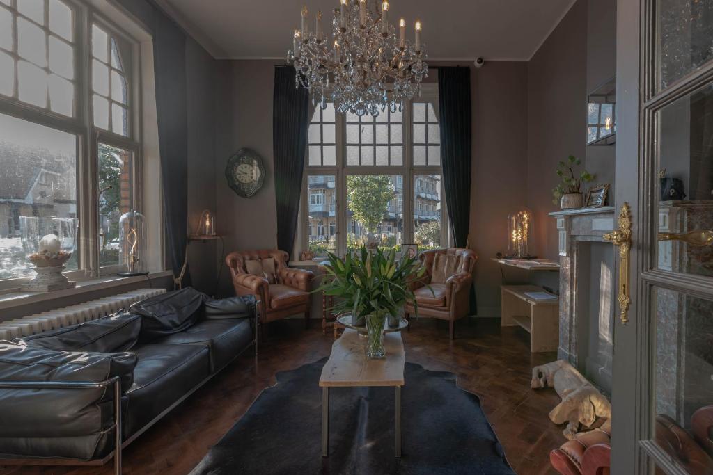 ein Wohnzimmer mit einem Sofa und einem Tisch in der Unterkunft Hotel Bonne Auberge (Adults Only) in De Haan