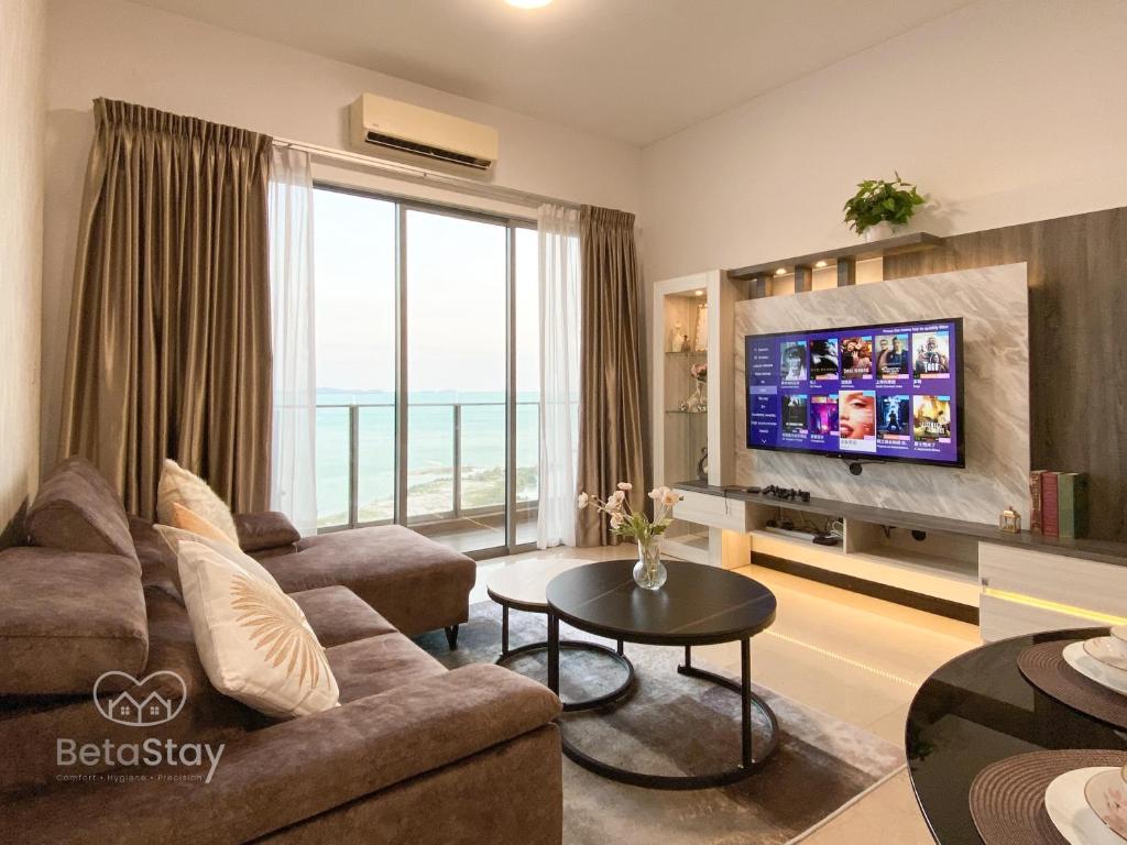 uma sala de estar com um sofá e uma televisão de ecrã plano em Seaview Suite SS Melaka by BetaStay em Malaca