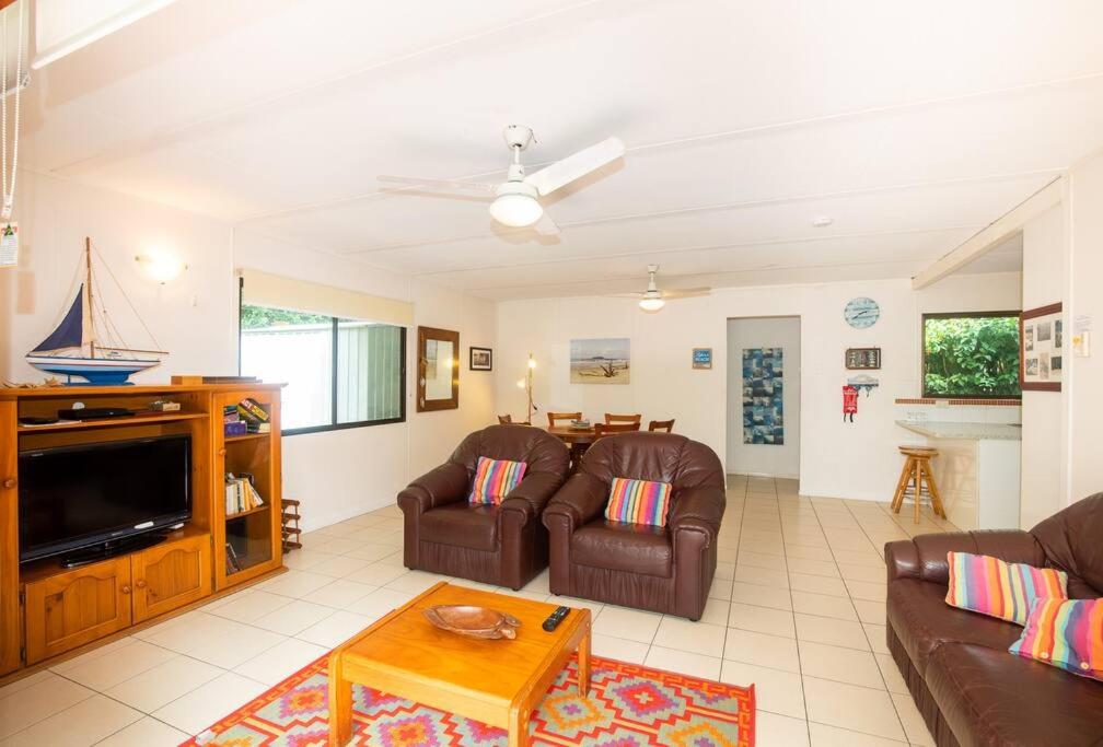 a living room with two couches and a tv at Allamanda Cottage - close to beach - pet friendly in Point Lookout