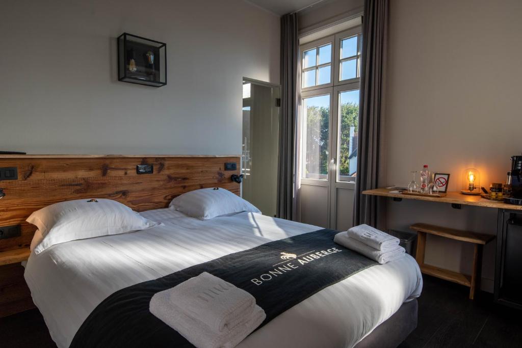 une chambre d'hôtel avec un lit et des serviettes. dans l'établissement Hotel Bonne Auberge (Adults Only), au Coq
