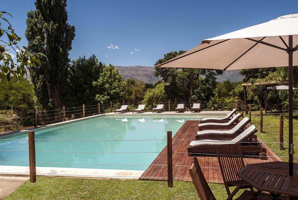 a swimming pool with chairs and an umbrella at Gran Hotel Nono in Nono