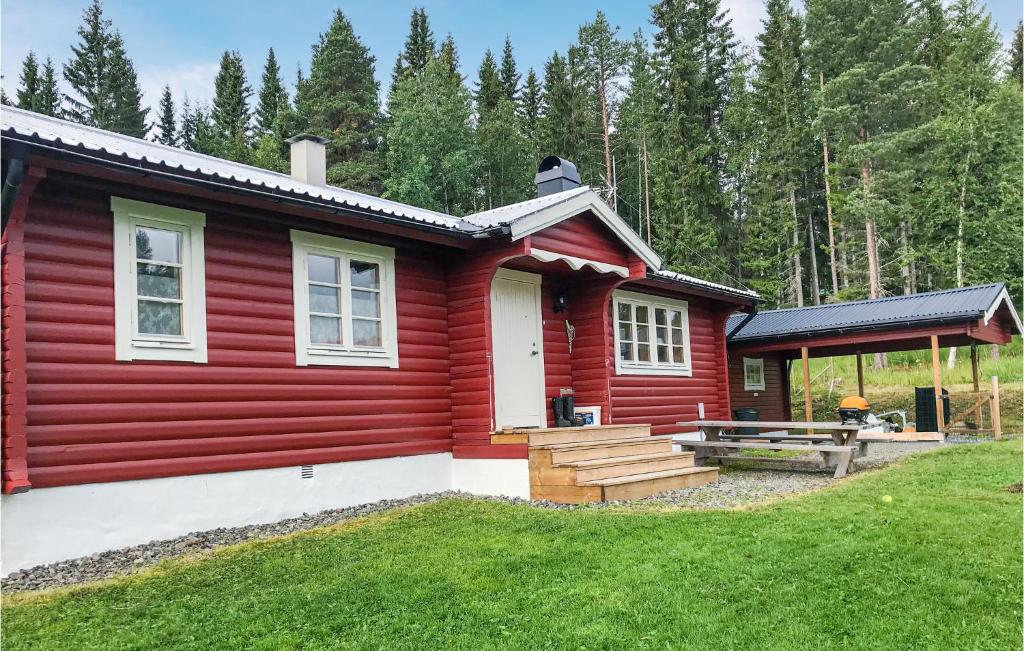 Lovely Home In Trngsviken With Kitchen في TrÃ¥ngsviken: منزل احمر امامه طاولة نزهة