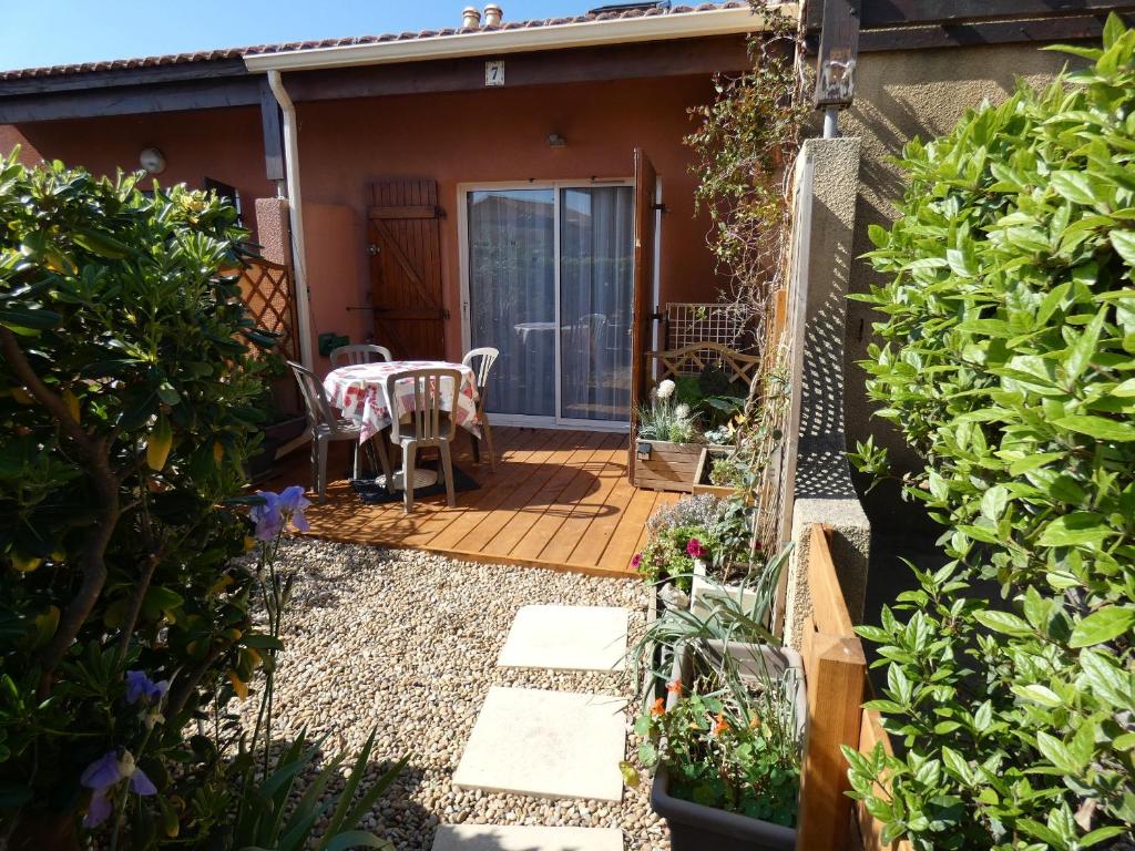 un pequeño jardín con una mesa y sillas en un patio en Pavillons 7 et 56 Narbonne Plage, en Narbonne-Plage