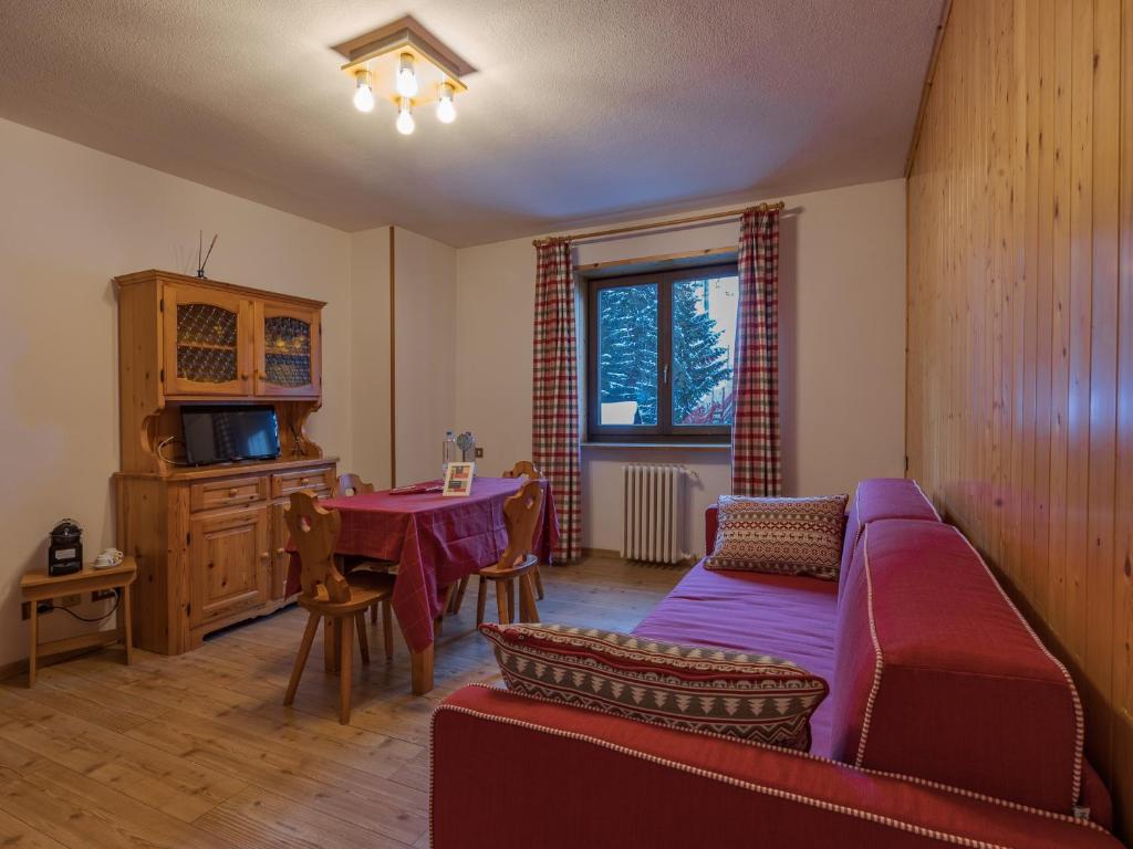 een woonkamer met een bank en een tafel bij Residenza 3-Tre in Madonna di Campiglio