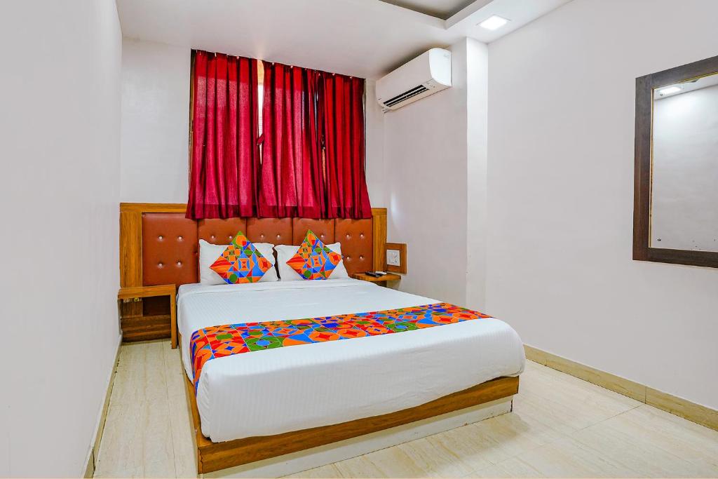 孟買的住宿－FabExpress Diamond I，一间卧室设有一张大床和红色窗户