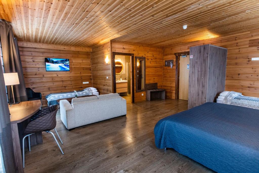 een slaapkamer met een bed en een bank in een kamer bij Lighthouse-Inn in Gardur