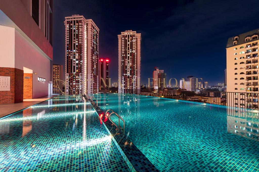 einem Pool auf einem Gebäude mit Skyline der Stadt in der Unterkunft Chambers Premier Suites Kuala Lumpur in Kuala Lumpur