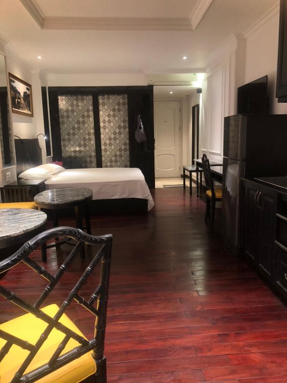 a hotel room with a bed and tables and chairs at My Stay Hotel & Apartment in Ho Chi Minh City