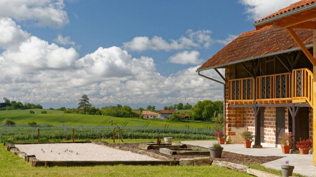 un bâtiment avec une terrasse et un champ de cultures dans l'établissement Le Cabanot, à Peyrusse-Grande