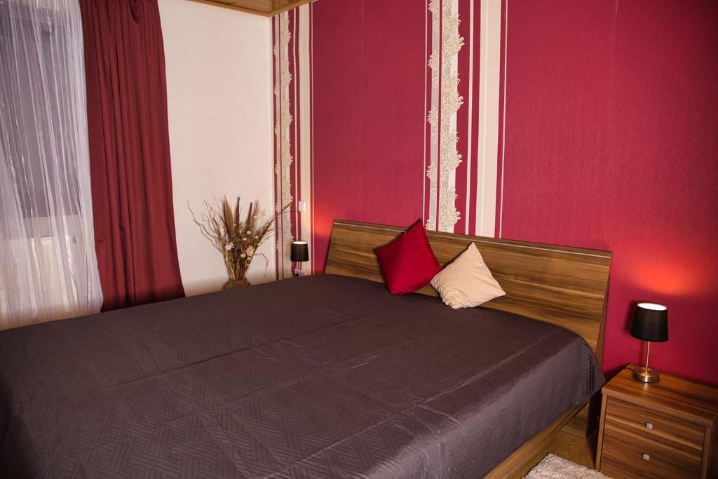 Haus Waldblick : غرفة نوم بسرير أسود وبجدران حمراء