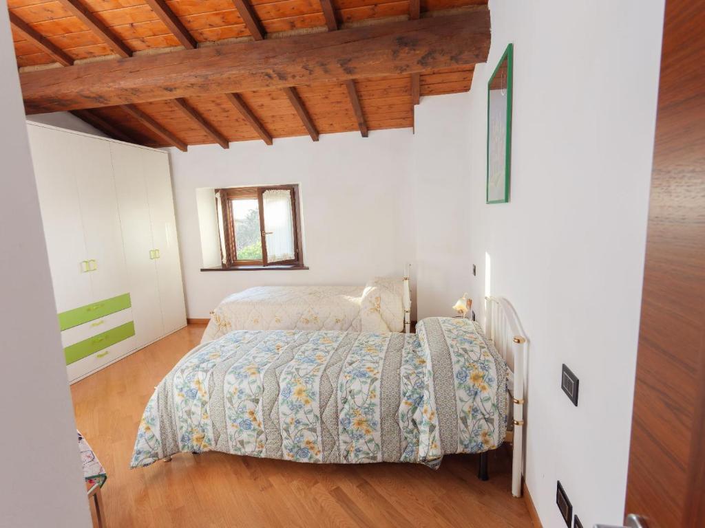 1 dormitorio con cama y techo de madera en Casa privata immersa nel verde con giardino e piscina, ad Assisi, en Mora