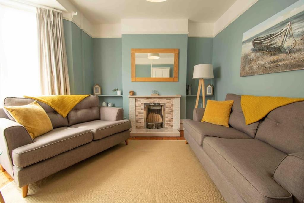 a living room with two couches and a fireplace at Tŷ Glas, Fishguard, Ideal for beach, coastal path and town! in Fishguard