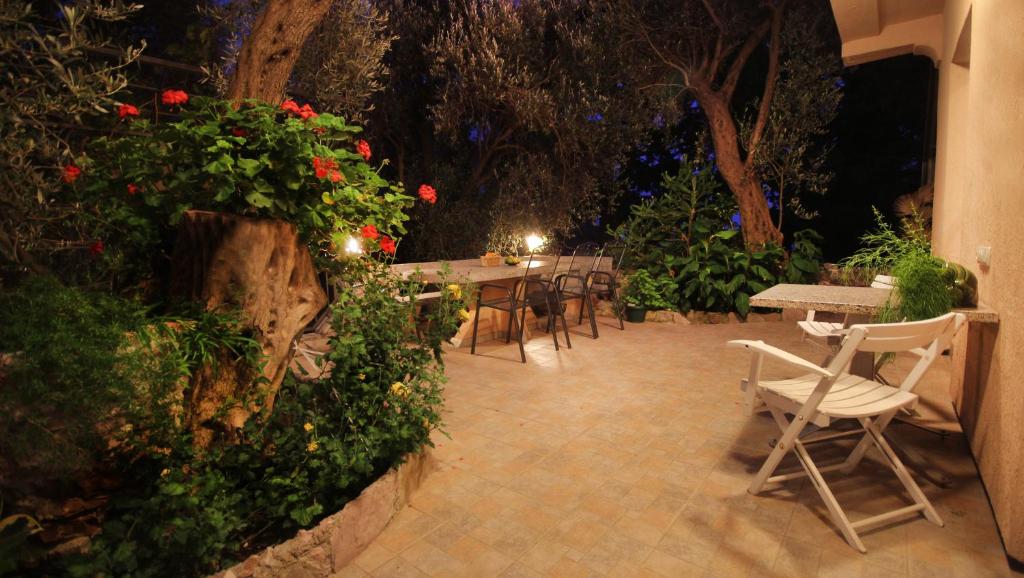 a patio with a table and chairs and flowers at Apartments Villa Slavica in Petrovac na Moru