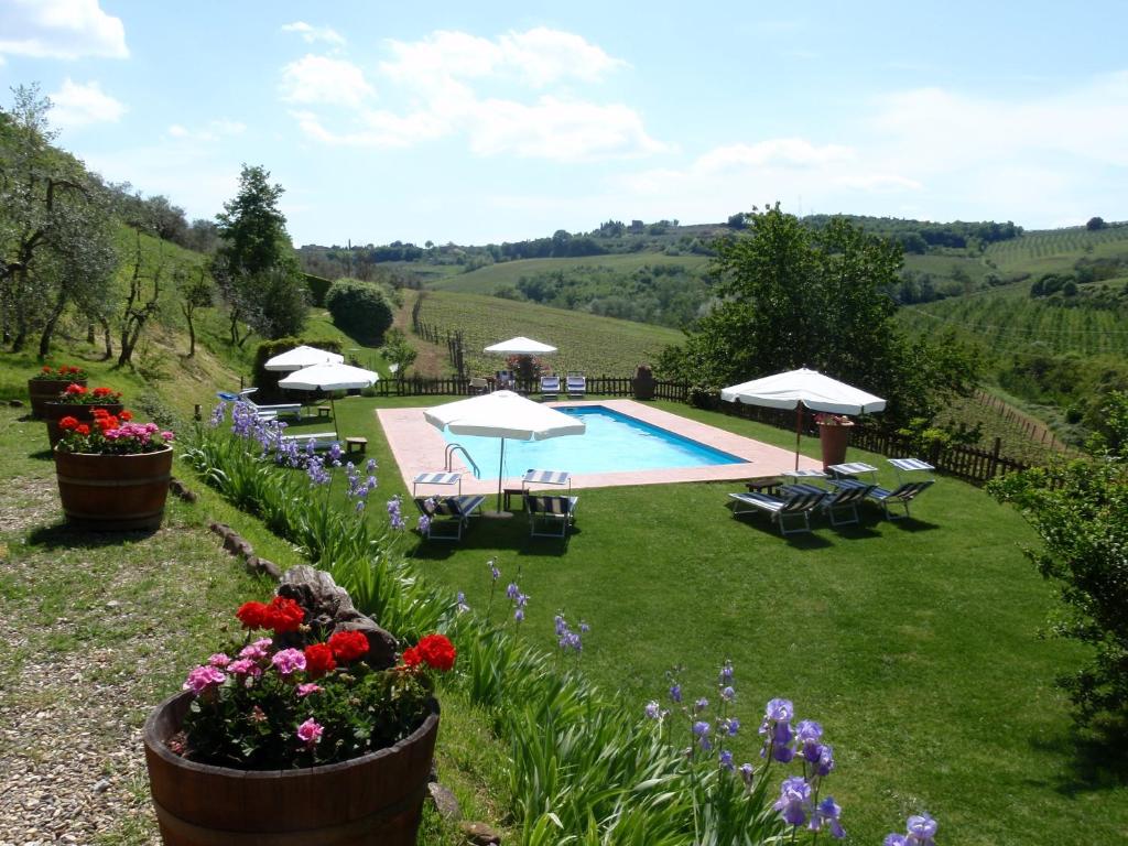 a garden with a swimming pool and some flowers at Agriturismo & Winery Il Bacio in Tavarnelle Val di Pesa