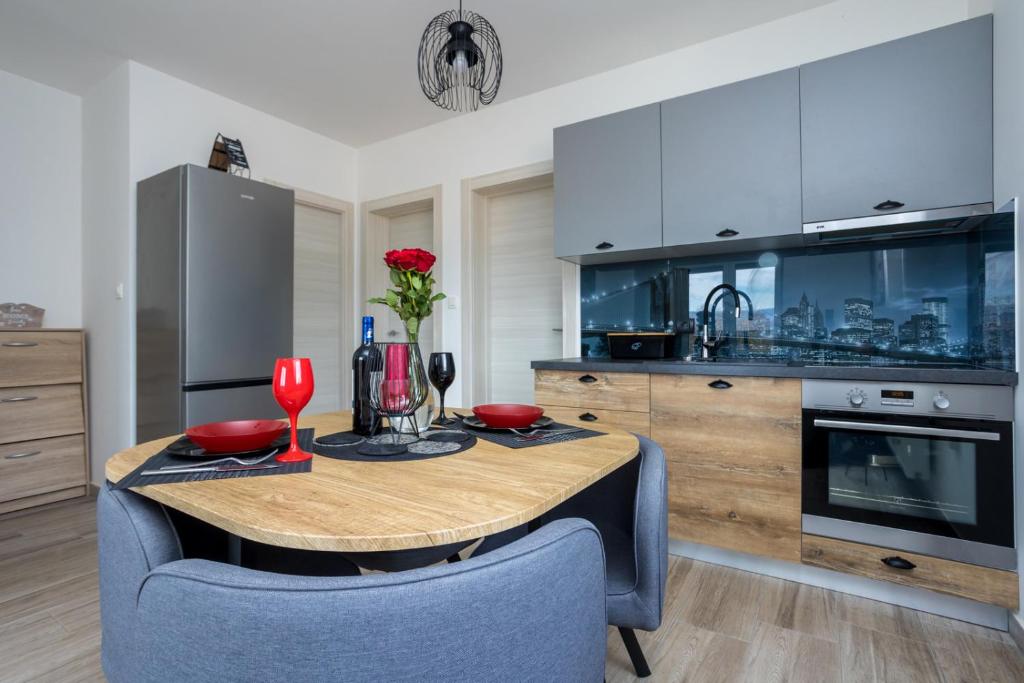 a kitchen with a wooden table and blue chairs at Apartment Kristina by EL-PI Tours in Županje