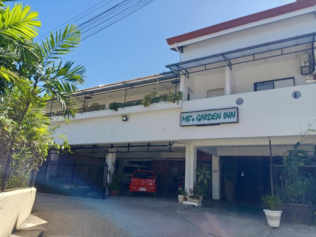 a garage with a red car inside of it at MB's Garden Inn in Mactan