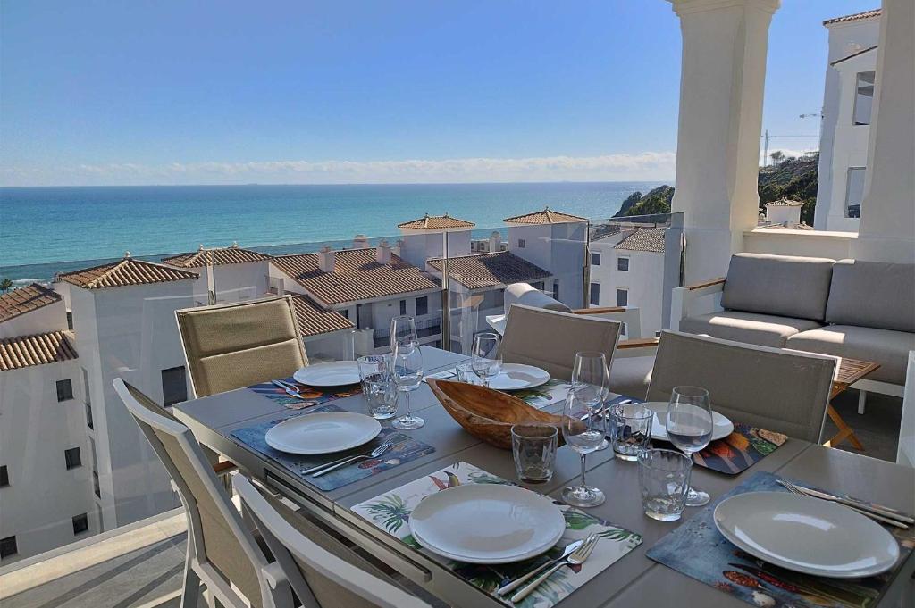 ein Tisch auf einem Balkon mit Blick auf das Meer in der Unterkunft Blue Suites in Manilva