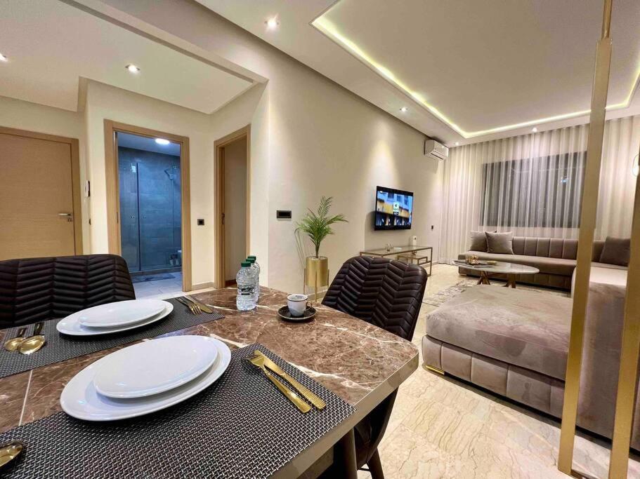 a living room with a dining table and a bed at Lovely Anfa City - By AppartAli in Casablanca