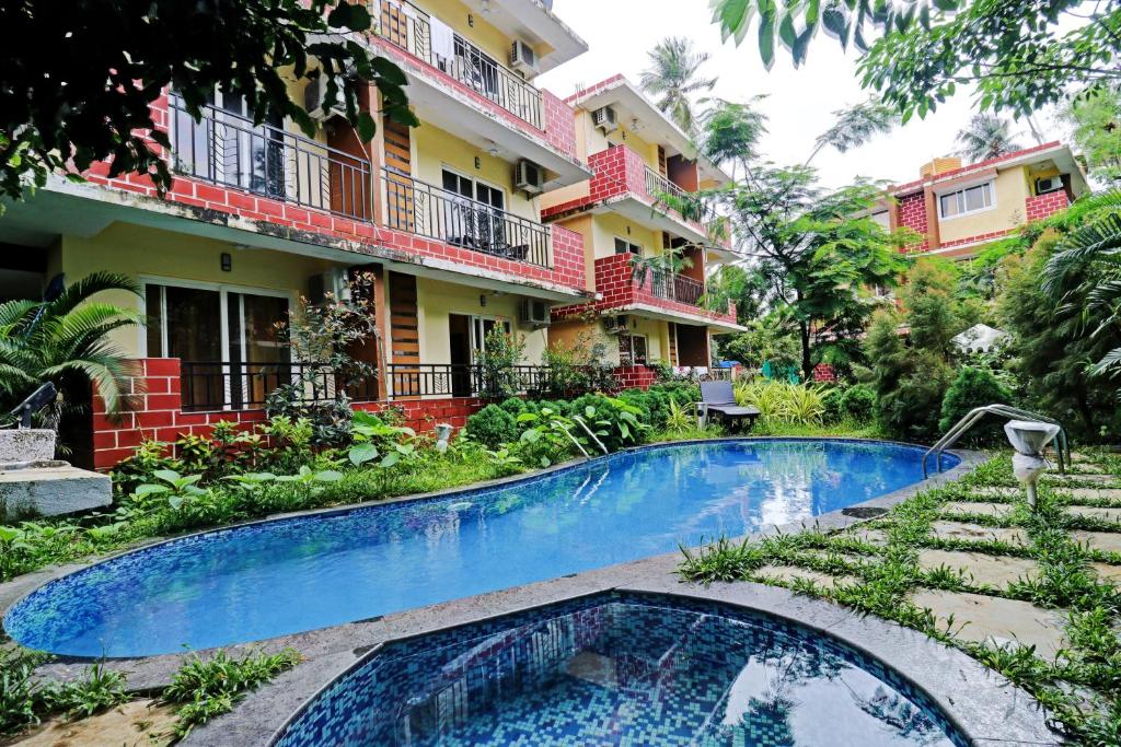 a resort with a swimming pool in front of a building at Mariners Bay Suites in Calangute