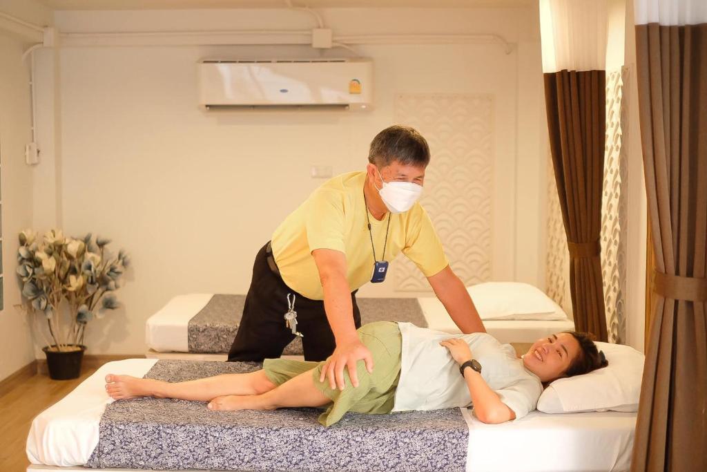 a man in a mask is giving a woman a massage at Tree Tara hotel in Lampang