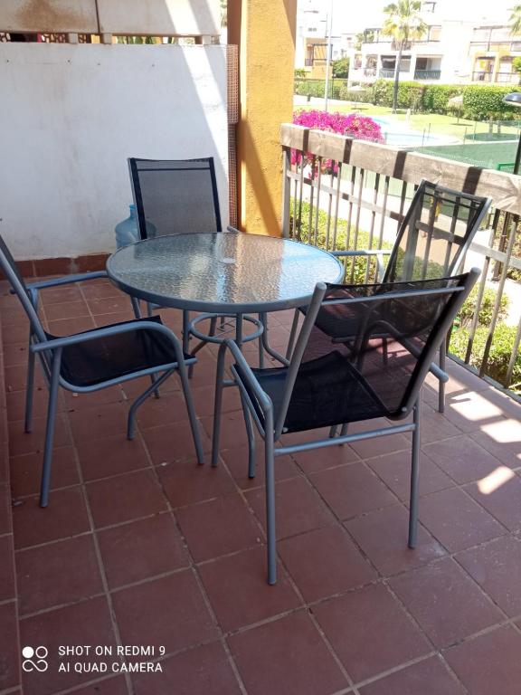 a glass table and chairs on a patio at Apartamento PUERTO REY 2 in Vera