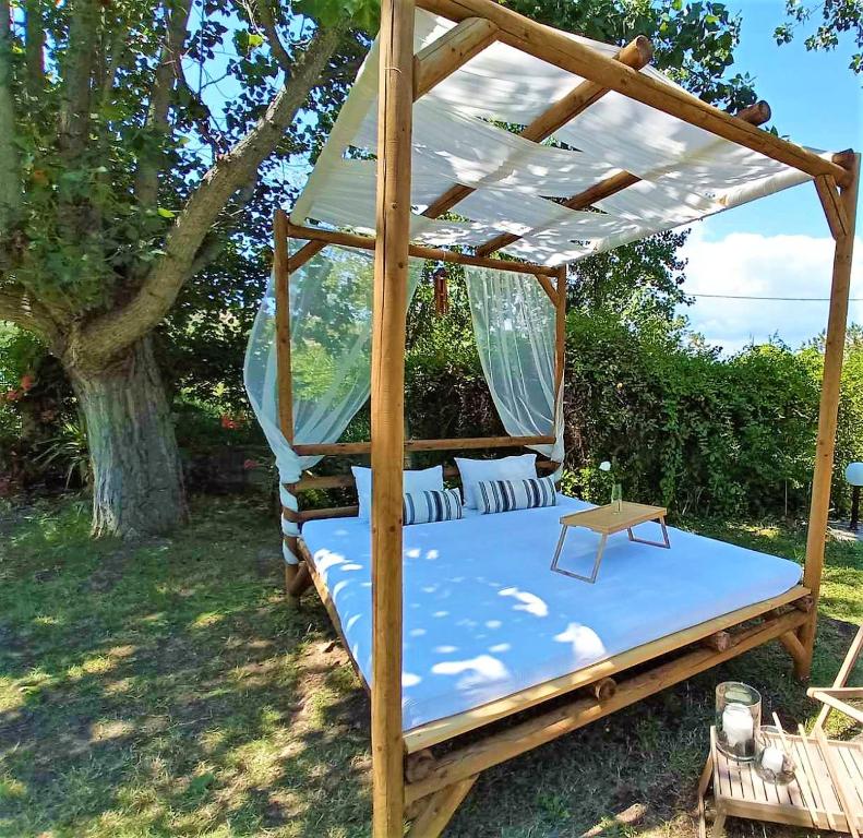 a bed frame with a canopy in a yard at Villa Elena in Vourvourou