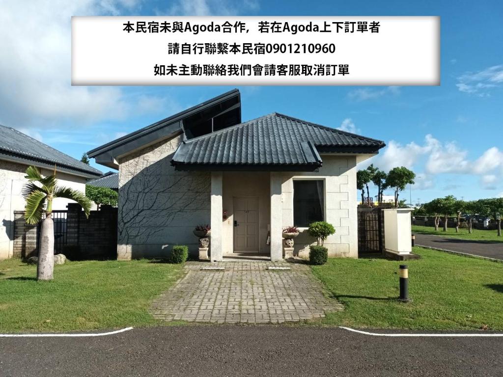una pequeña casa con techo negro en 艸祭莊園 en Pi-tzu-t'ou
