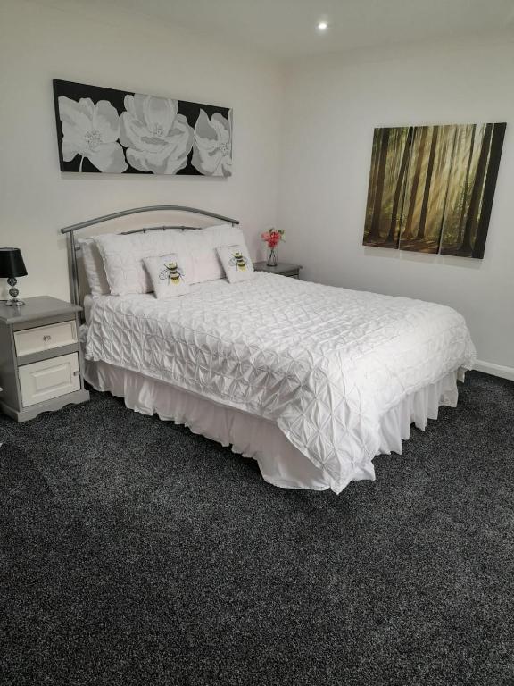 1 dormitorio con cama blanca y mesita de noche en riverside rooms at wheelgate house, en Goole