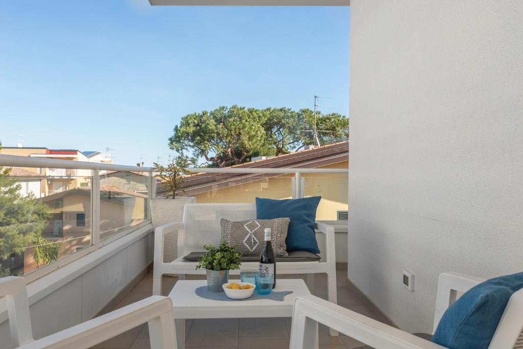 a balcony with a table and a bottle of wine at VIRGILIO - Narramondo Villas in Tortoreto Lido