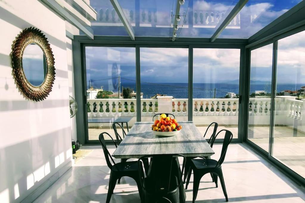 uma sala de jantar com uma mesa com uma taça de fruta em The White House Beach Villa em Rafina