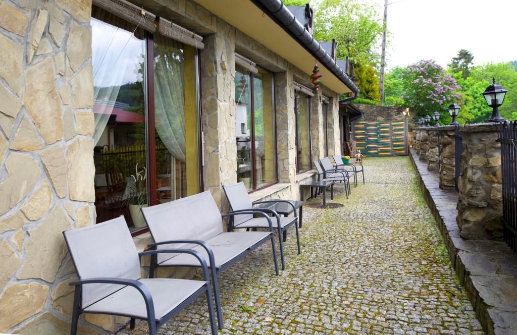 a row of chairs sitting outside of a building at Bajka in Krynica Zdrój