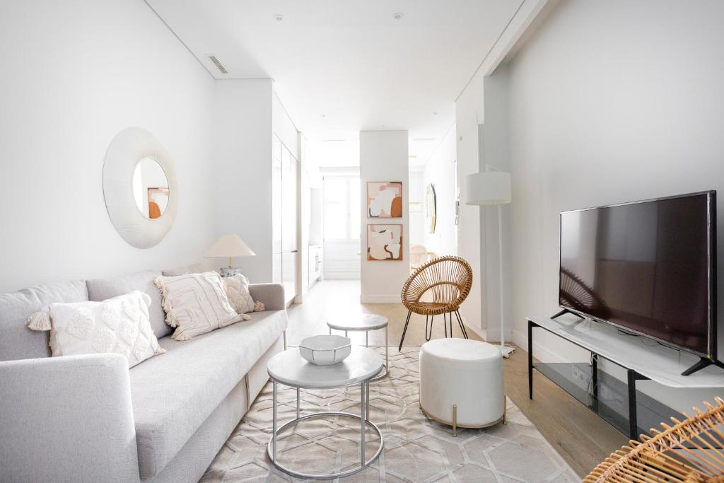 sala de estar blanca con sofá y TV en Palafox Design - Darya Living, en Madrid