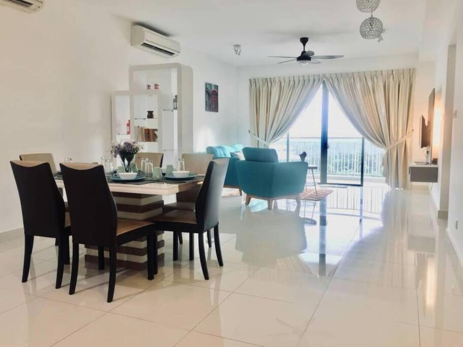 a dining room and living room with a table and chairs at 2 bedder Seaview condo with Wifi near Legoland for 6 pax in Nusajaya