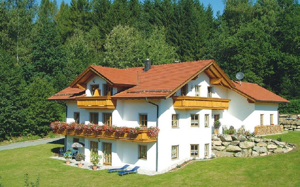 a large white house with a red roof at Ferienwohnung Reisinger in Arnbruck