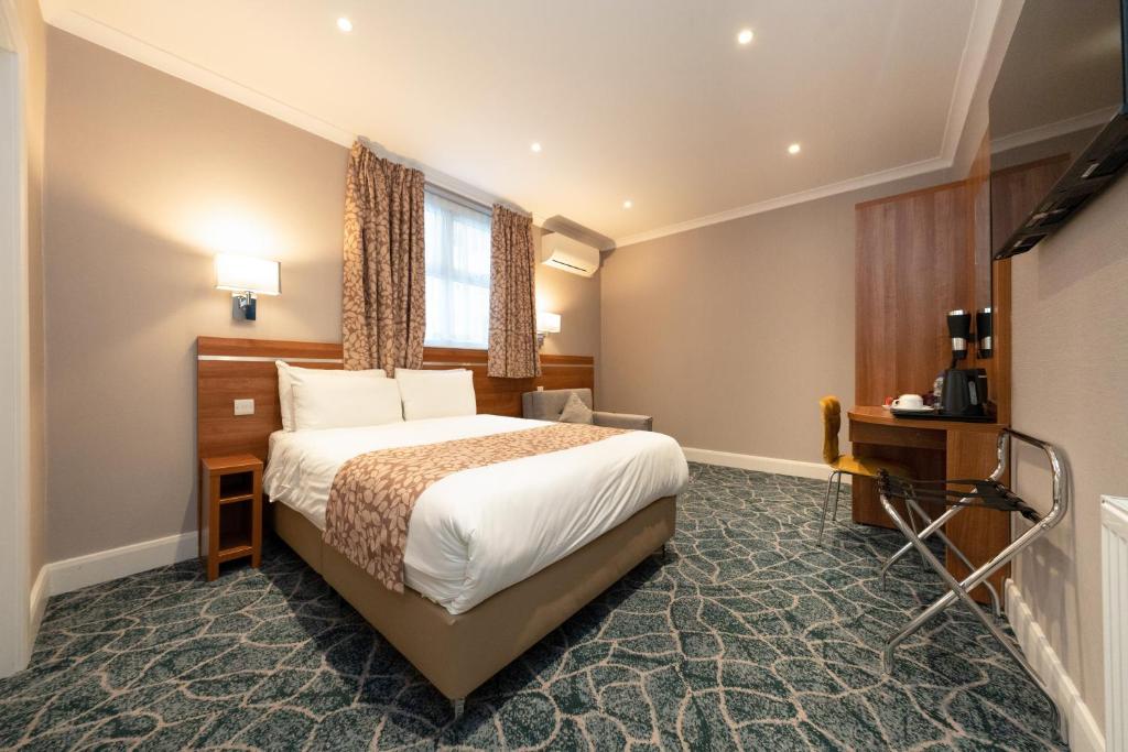 a hotel room with a bed and a window at Park Avenue Bayswater Inn Hyde Park in London