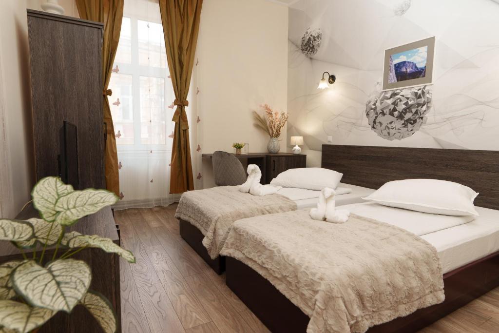 um quarto com 2 camas e almofadas brancas em Hotel Rubin*** em Gheorgheni