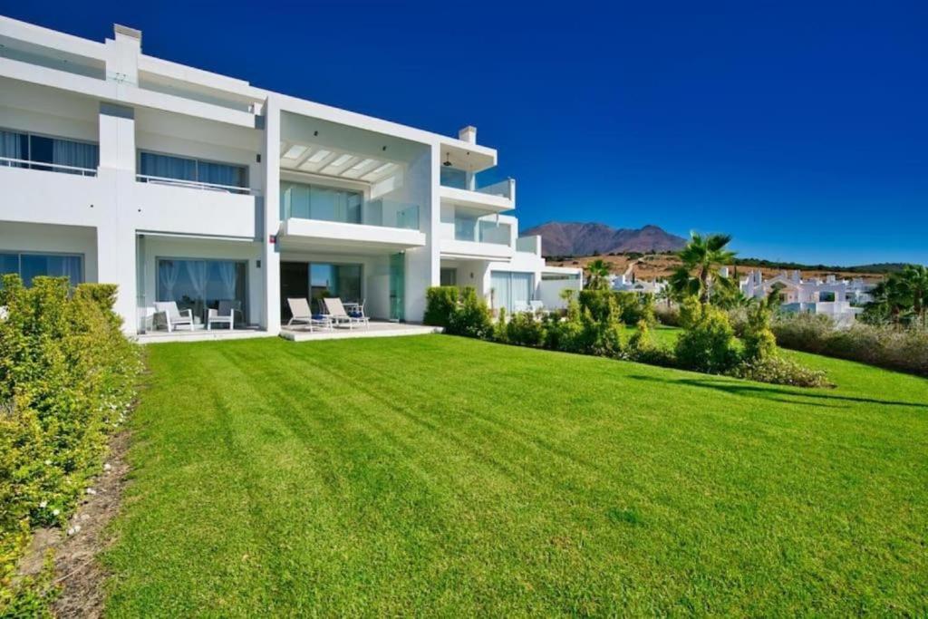 a large lawn in front of a white building at Al-1103 Estepona - Apartment - Alcazaba Lagoon in Estepona