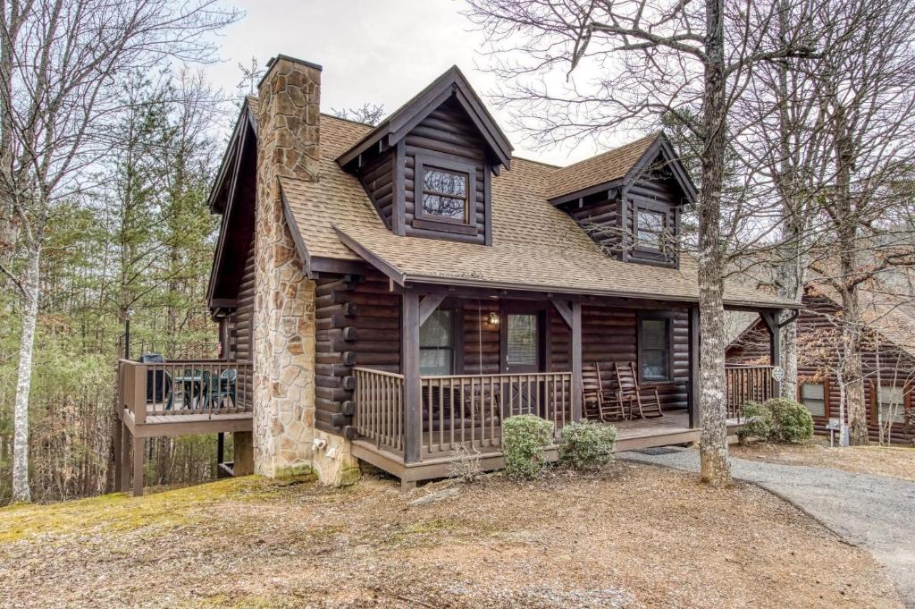 ER74 - Gerrald's Chalet - Great location, Close to all the action! cabin في بيدجن فورج: منزل خشبي مع شرفة وسطح