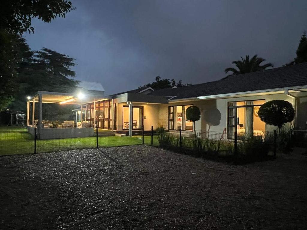uma casa iluminada à noite com as luzes acesas em Le'Ciara Luxury Guest House em Joanesburgo