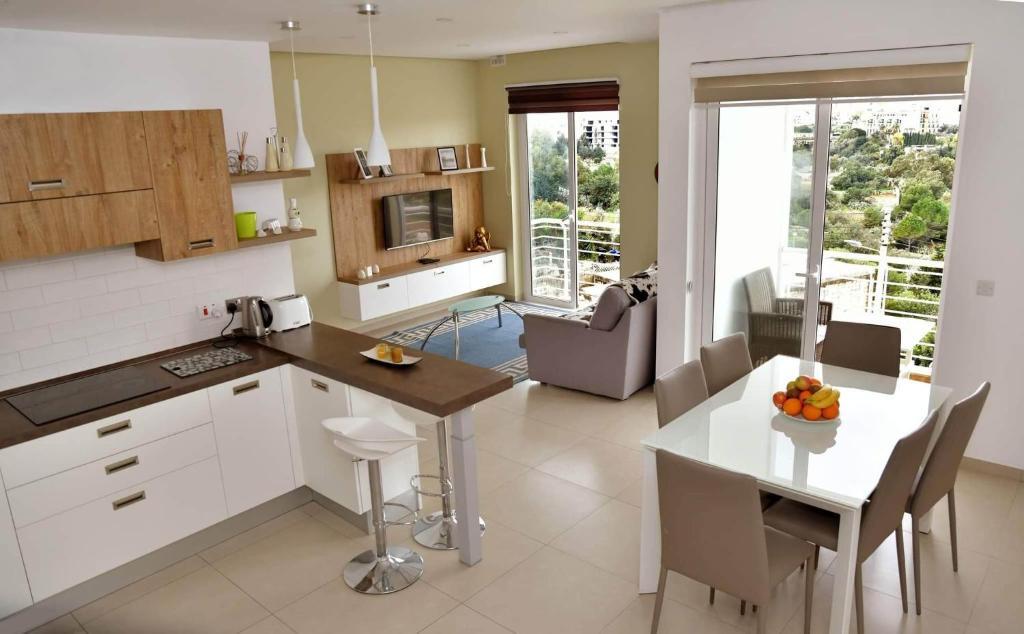cocina y sala de estar con mesa y sillas en Valley of Honey Apartment en Mosta