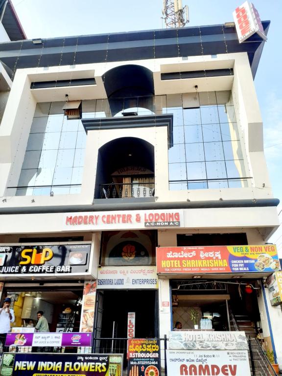 un edificio con molti cartelli di fronte di Hotel Madery a Mangalore