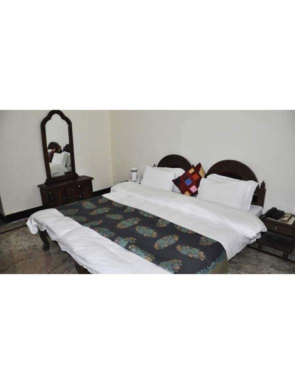 1 dormitorio con 1 cama grande con sábanas blancas en Hotel Padmini, Chittorgarh, en Chittorgarh